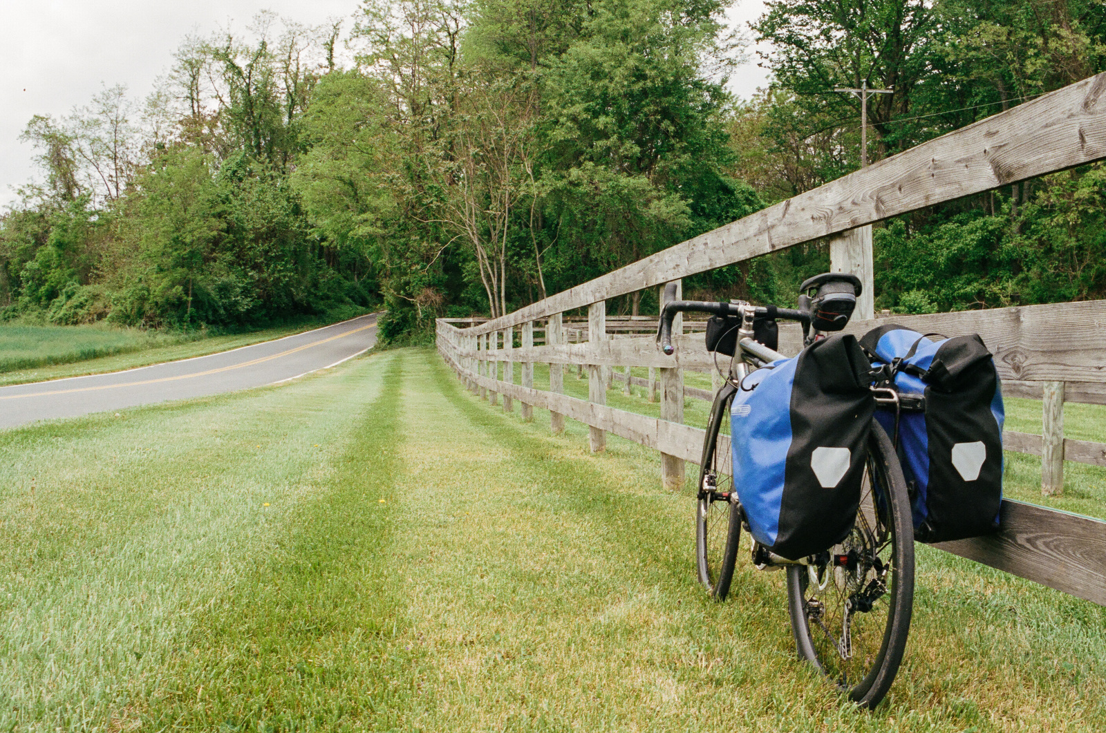a bicycle leans up against a wooden fence